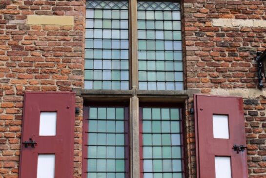 monumentaal kruisvenster met houten draairamen.